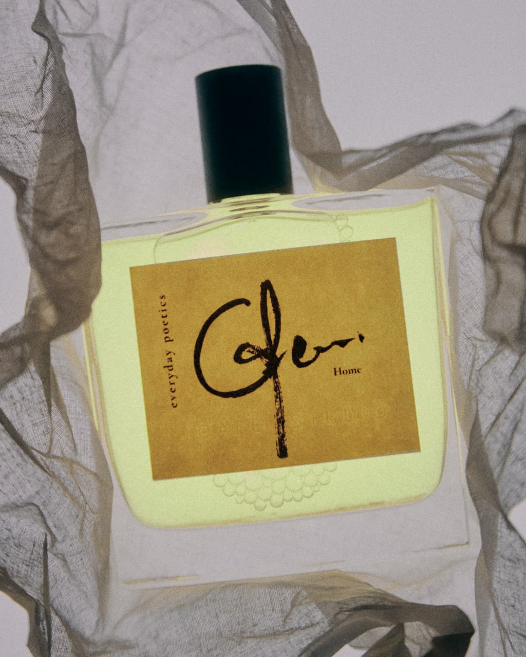 Everyday Poetics fragrance bottle on fabric background.